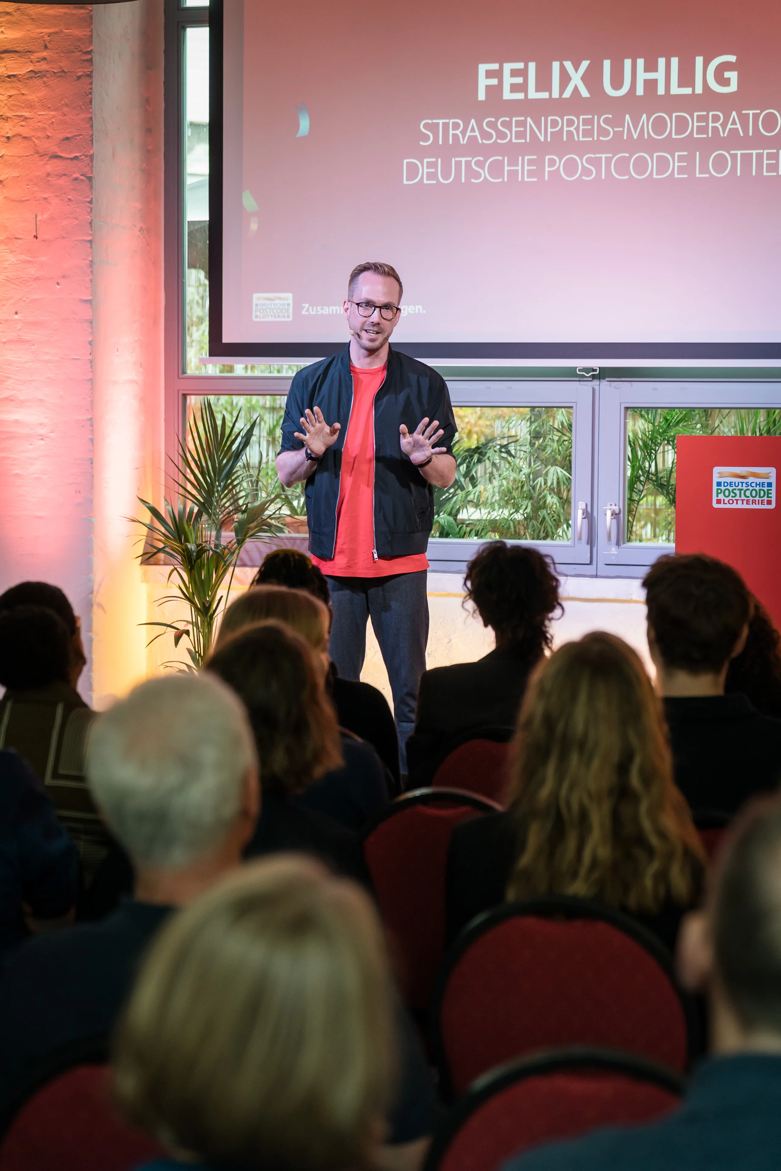 Moderator Felix Uhlig auf der Bühne des Partnertreffens der Deutschen Postcode Lotterie 2025 in Berlin